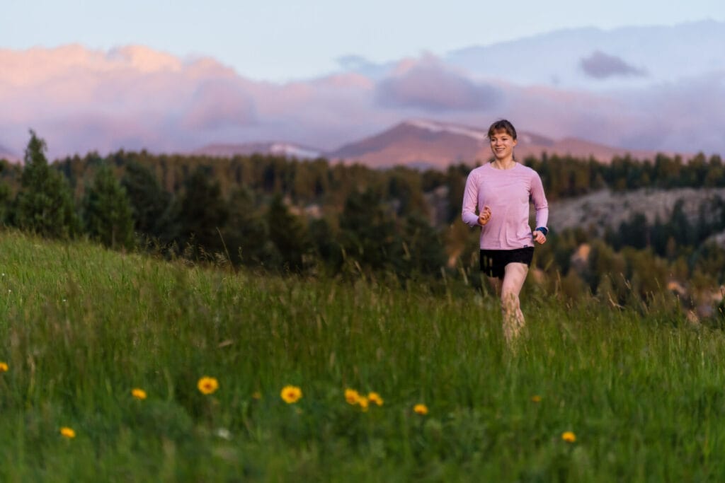 A woman trail running at Three Sisters/Alderfer park in Evergreen, Colorado.