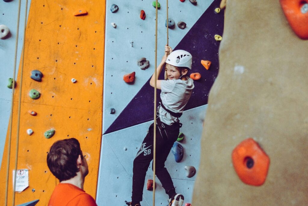 little boy on a rock climbing wall in a climbing gym
